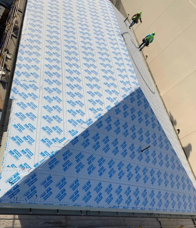 Professional roofers installing underlayment on a metal roof in Stonegate